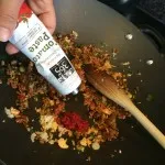 Adding tomato paste to the mixture of meat and vegetables in Boston, MA
