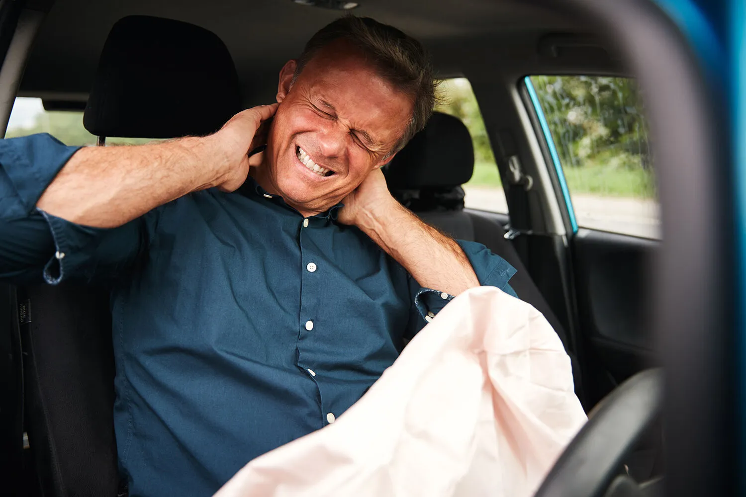 man suffering a whiplash inside the car